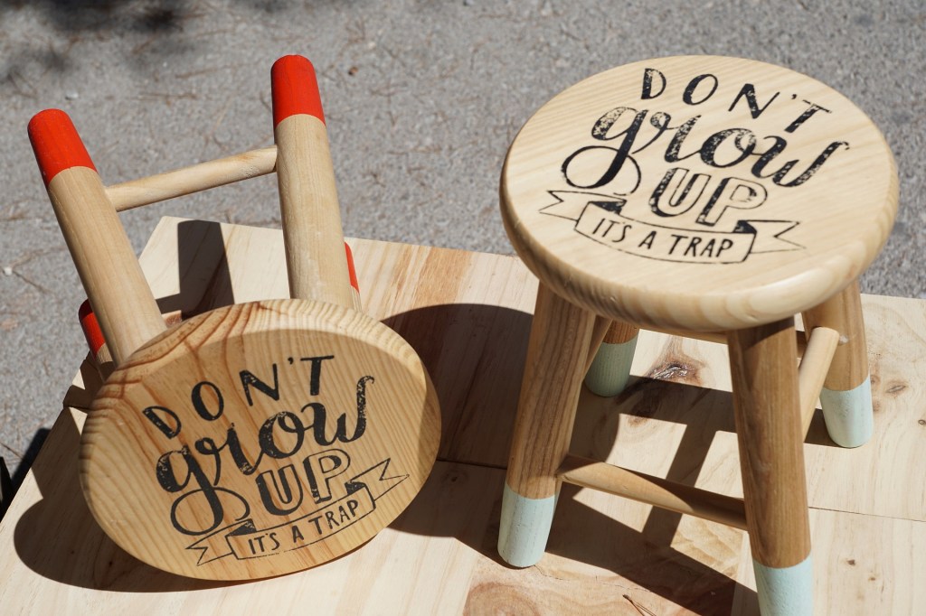 stools with writing on them: "Don't grow up it's a trap"